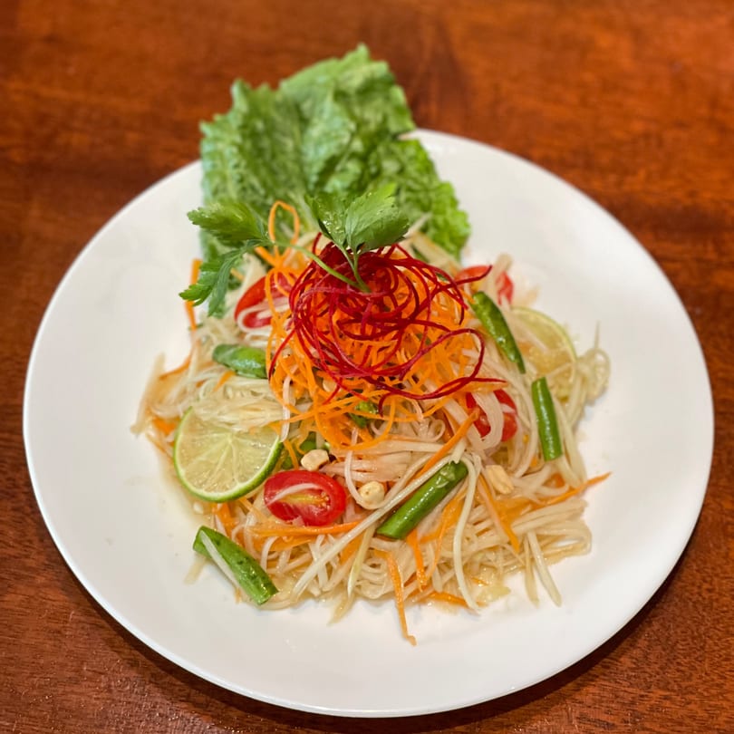 My Black Thai's Som Tum, a vibrant papaya salad with lime, tomatoes, and green beans.